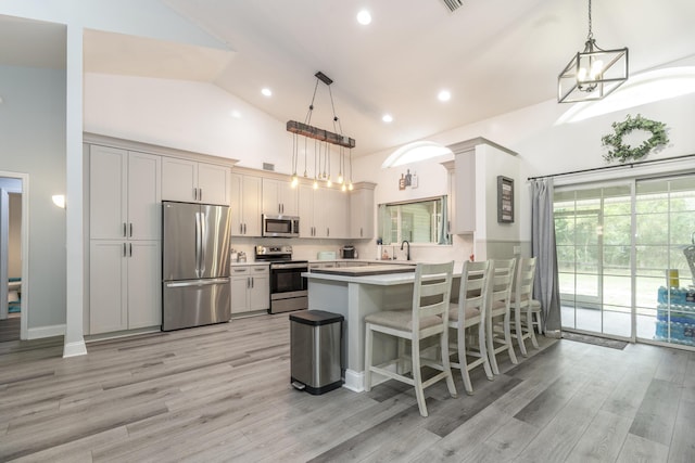 17069 81st Ln N, Loxahatchee, FL 33470 - kitchen featuring stainless steel appliances, high vaulted ceiling, a peninsula, light wood-style floors, and light countertops