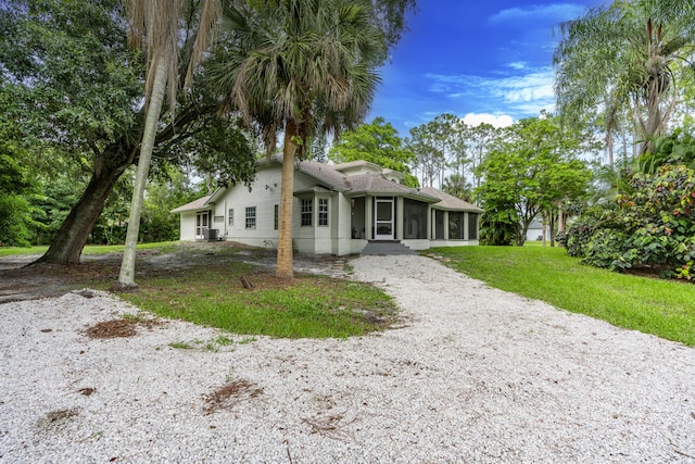 17069 81st Ln N, Loxahatchee, FL 33470 - rear view of property with a sunroom, driveway, and a lawn