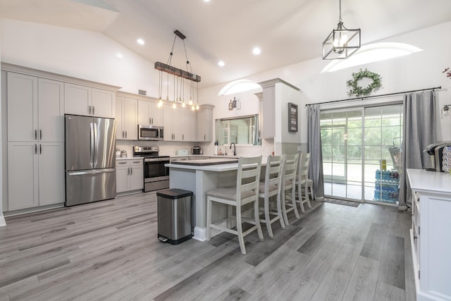 17069 81st Ln N, Loxahatchee, FL 33470 - kitchen featuring stainless steel appliances, a peninsula, light countertops, light wood finished floors, and high vaulted ceiling