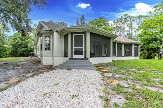 17069 81st Ln N, Loxahatchee, FL 33470 - view of front of house with a sunroom, a shingled roof, central air condition unit, and entry steps
