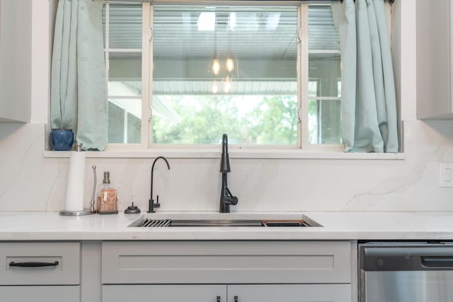 17069 81st Ln N, Loxahatchee, FL 33470 - kitchen featuring stainless steel dishwasher, a sink, backsplash, and white cabinetry