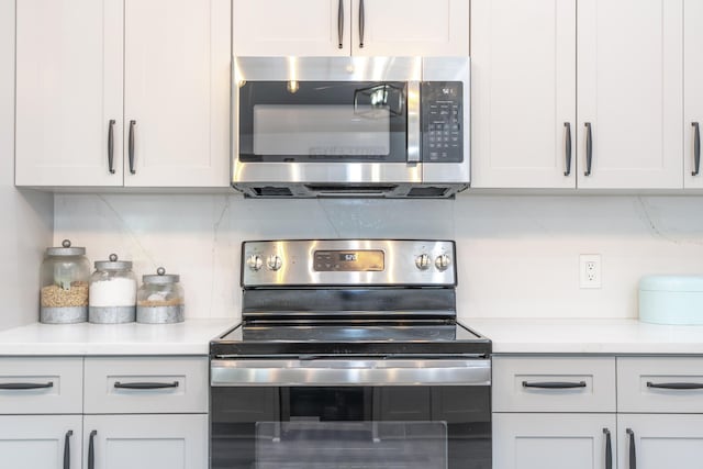 17069 81st Ln N, Loxahatchee, FL 33470 - kitchen featuring appliances with stainless steel finishes, light countertops, white cabinetry, and decorative backsplash