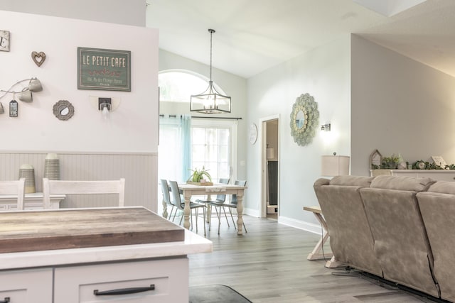 17069 81st Ln N, Loxahatchee, FL 33470 - kitchen with vaulted ceiling, a chandelier, light wood-style flooring, white cabinets, and pendant lighting