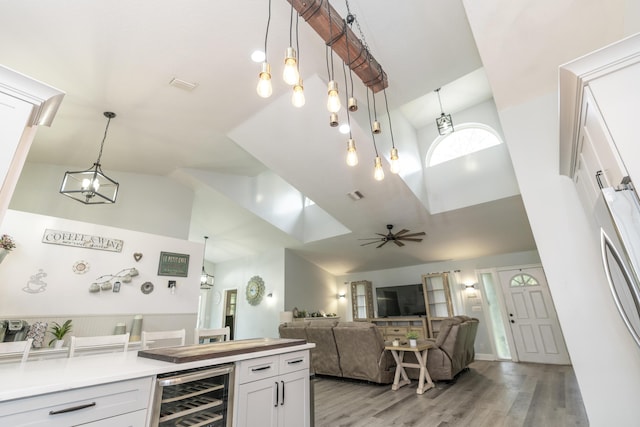 17069 81st Ln N, Loxahatchee, FL 33470 - kitchen with beverage cooler, high vaulted ceiling, light wood finished floors, decorative light fixtures, and light countertops