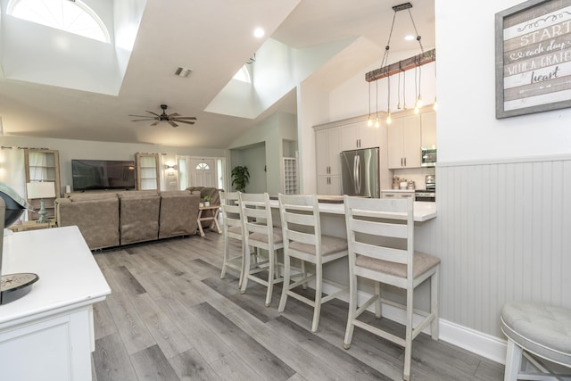 17069 81st Ln N, Loxahatchee, FL 33470 - kitchen with stainless steel appliances, a breakfast bar, light wood-type flooring, a ceiling fan, and open floor plan
