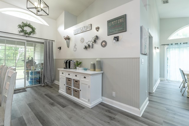 17069 81st Ln N, Loxahatchee, FL 33470 - interior space with wood finished floors, wainscoting, a chandelier, baseboards, and high vaulted ceiling