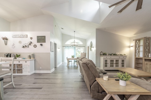 17069 81st Ln N, Loxahatchee, FL 33470 - living room featuring a chandelier, light wood-type flooring, wainscoting, and high vaulted ceiling