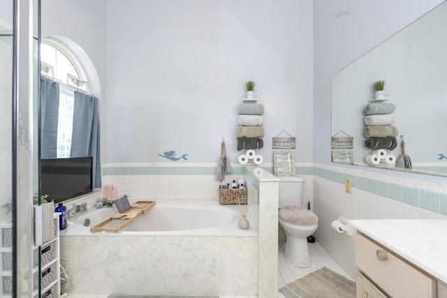 17069 81st Ln N, Loxahatchee, FL 33470 - bathroom featuring a garden tub, toilet, vanity, tile patterned floors, and a wainscoted wall
