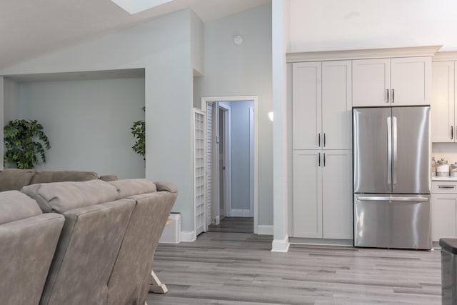 17069 81st Ln N, Loxahatchee, FL 33470 - kitchen with freestanding refrigerator, lofted ceiling, open floor plan, light wood-type flooring, and baseboards