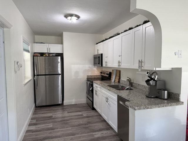 408 S 9th St, Lantana, FL 33462 - kitchen featuring stainless steel appliances, a sink, white cabinetry, and dark wood-style floors