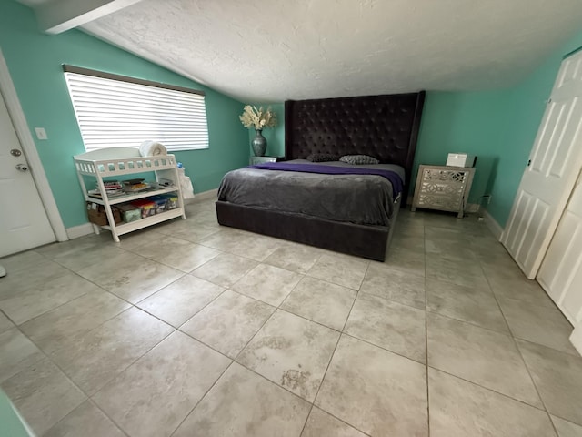 408 S 9th St, Lantana, FL 33462 - bedroom with lofted ceiling, tile patterned flooring, baseboards, and a textured ceiling