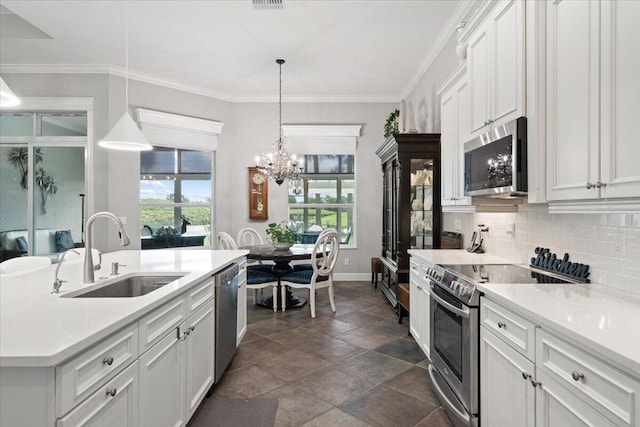 9926 SW Nuova Way, Port Saint Lucie, FL 34986 - kitchen with a sink, stainless steel appliances, a chandelier, dark stone finish floors, and decorative backsplash