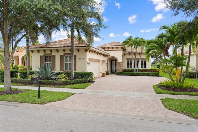 9926 SW Nuova Way, Port Saint Lucie, FL 34986 - mediterranean / spanish-style house featuring an attached garage, stucco siding, decorative driveway, and a tile roof