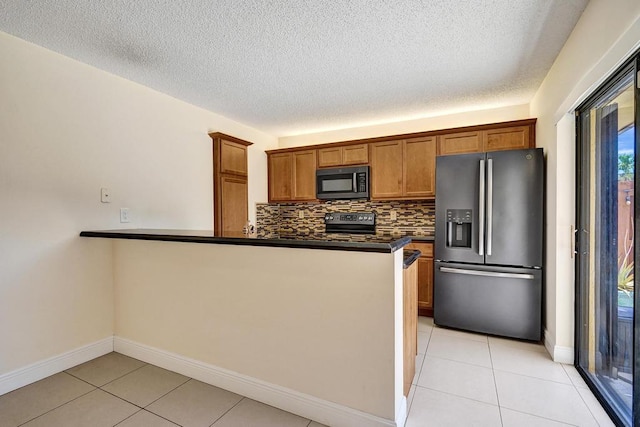 973 Springdale Cir Unit 97-C, Palm Springs, FL 33461 - kitchen with black appliances, dark countertops, brown cabinets, a peninsula, and light tile patterned floors