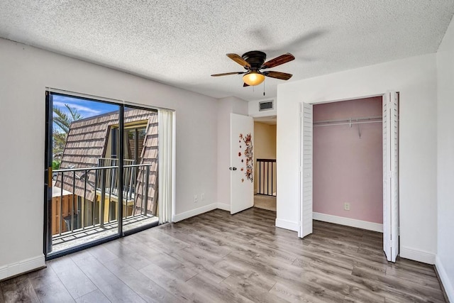 973 Springdale Cir Unit 97-C, Palm Springs, FL 33461 - unfurnished bedroom featuring access to outside, wood finished floors, a textured ceiling, baseboards, and a ceiling fan