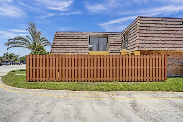 973 Springdale Cir Unit 97-C, Palm Springs, FL 33461 - view of property exterior featuring mansard roof, uncovered parking, and brick siding