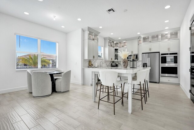 5609 Zestar Ln, The Acreage, FL 33470 - kitchen featuring appliances with stainless steel finishes, light countertops, baseboards, recessed lighting, and a breakfast bar area