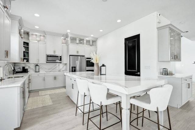 5609 Zestar Ln, The Acreage, FL 33470 - kitchen featuring a sink, stainless steel appliances, light wood-style floors, light stone counters, and recessed lighting