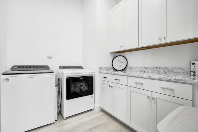 5609 Zestar Ln, The Acreage, FL 33470 - laundry area featuring washing machine and clothes dryer, cabinet space, and light wood-type flooring
