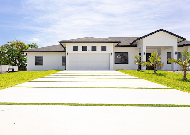 640 Marshall Rd, West Palm Beach, FL 33413 - view of front of home with an attached garage, concrete driveway, stucco siding, a front lawn, and roof with shingles