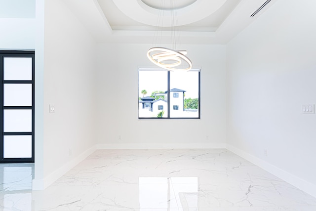 640 Marshall Rd, West Palm Beach, FL 33413 - empty room with baseboards, marble finish floors, a tray ceiling, and a chandelier