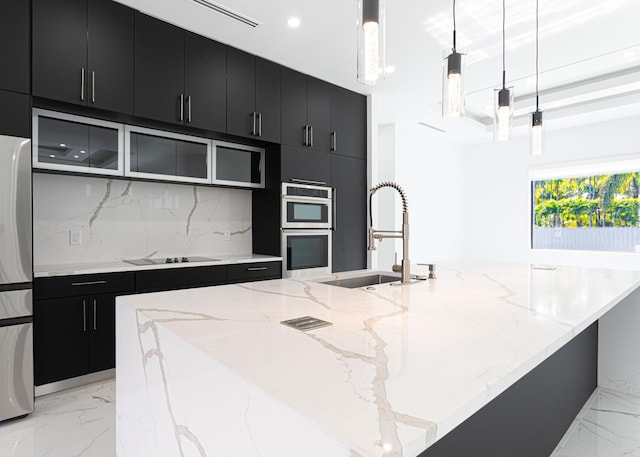 640 Marshall Rd, West Palm Beach, FL 33413 - kitchen with dark cabinetry, a sink, a large island with sink, light marble finish flooring, and recessed lighting