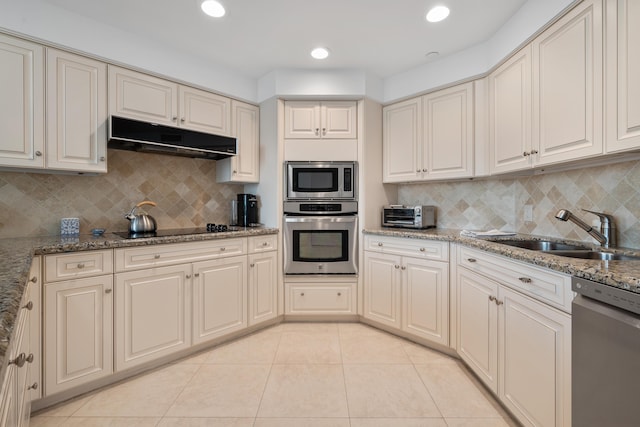 20310 Fairway Oaks Dr Unit 161, Boca Raton, FL 33434 - kitchen featuring appliances with stainless steel finishes, under cabinet range hood, light tile patterned floors, decorative backsplash, and light stone counters