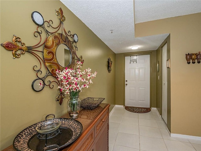 1590 S 42nd Cir Unit 106, Vero Beach, FL 32967 - entrance foyer featuring a textured ceiling, light tile patterned floors, and baseboards