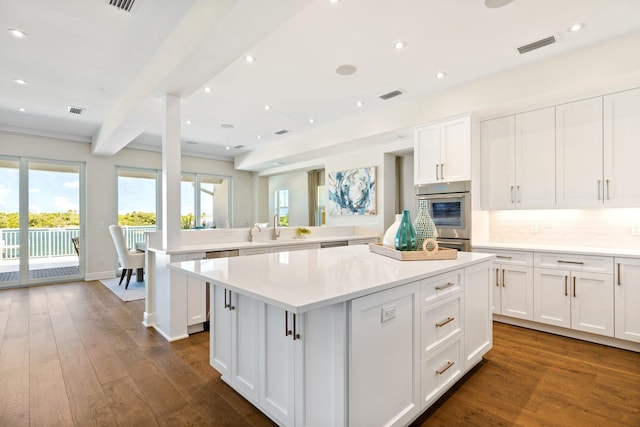 18119 SE Federal Hwy, Tequesta, FL 33469 - kitchen featuring a center island, a peninsula, light countertops, a sink, and beamed ceiling