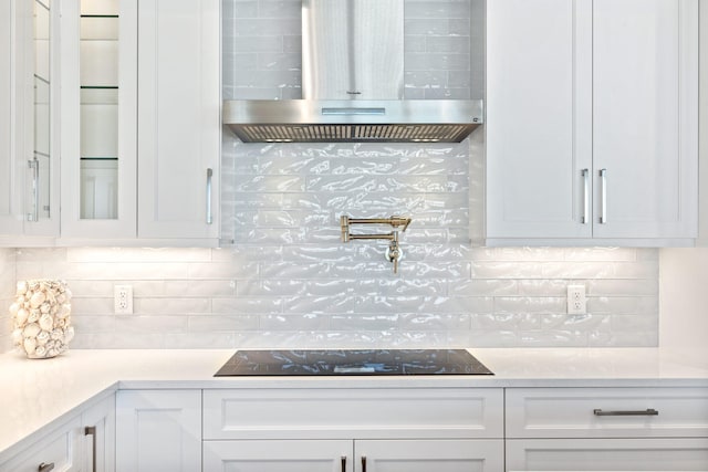 18119 SE Federal Hwy, Tequesta, FL 33469 - kitchen featuring exhaust hood, decorative backsplash, black electric stovetop, and white cabinetry