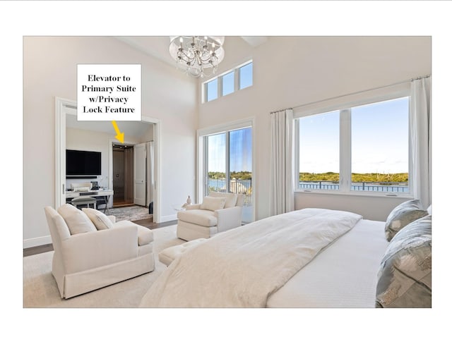 18119 SE Federal Hwy, Tequesta, FL 33469 - bedroom with a chandelier, a high ceiling, baseboards, and wood finished floors
