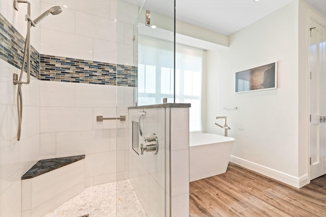 18119 SE Federal Hwy, Tequesta, FL 33469 - bathroom featuring a stall shower, a freestanding bath, baseboards, and wood finished floors