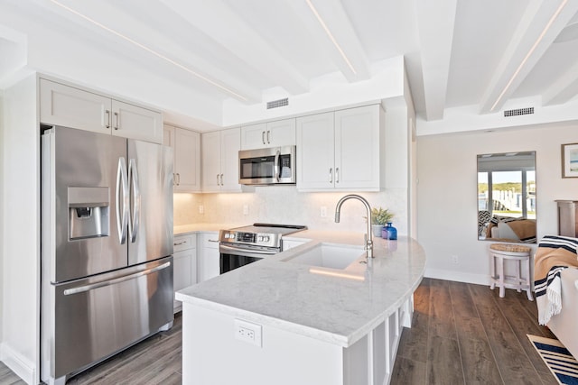 18119 SE Federal Hwy, Tequesta, FL 33469 - kitchen featuring stainless steel appliances, a sink, a peninsula, beamed ceiling, and light stone countertops