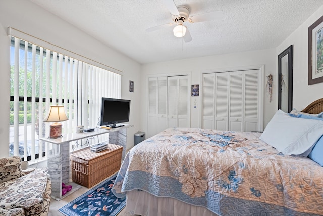 5200 SE Seascape Way Unit 201, Stuart, FL 34997 - carpeted bedroom featuring two closets, a textured ceiling, and a ceiling fan