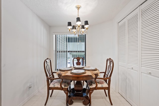 5200 SE Seascape Way Unit 201, Stuart, FL 34997 - dining space with a chandelier, a textured ceiling, baseboards, and light tile patterned flooring
