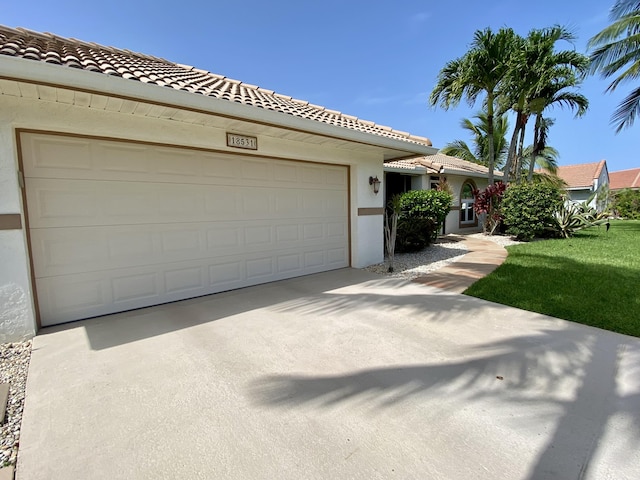 18531 Anchor Dr, Boca Raton, FL 33498 - view of front of home with driveway, a garage, stucco siding, and a tiled roof