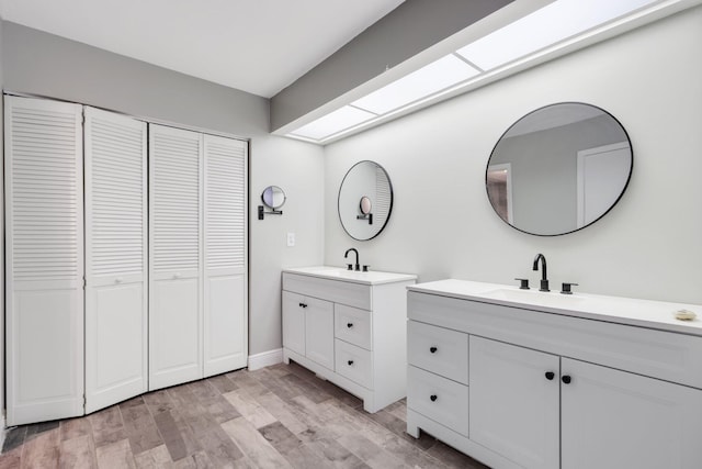 3665 Sliver Lace Ln Unit 80, Boynton Beach, FL 33436 - bathroom featuring a closet, two vanities, and wood finished floors