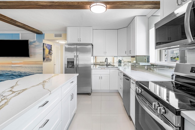 2020 Lake Osborne Dr Unit 10, Lake Worth, FL 33461 - kitchen with appliances with stainless steel finishes, light stone countertops, white cabinets, beam ceiling, and light tile patterned floors