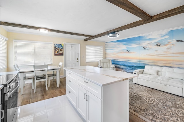 2020 Lake Osborne Dr Unit 10, Lake Worth, FL 33461 - kitchen with stainless steel electric range oven, beamed ceiling, white cabinets, open floor plan, and a kitchen island