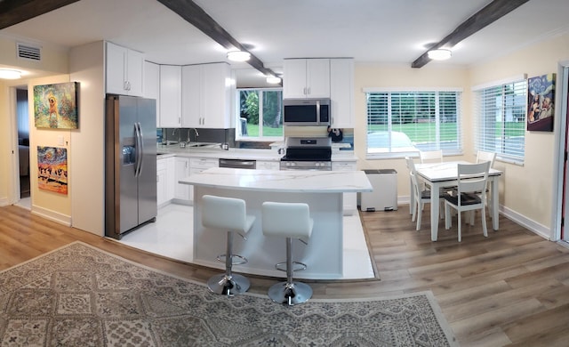 2020 Lake Osborne Dr Unit 10, Lake Worth, FL 33461 - kitchen with stainless steel appliances, light countertops, light wood-type flooring, plenty of natural light, and beam ceiling