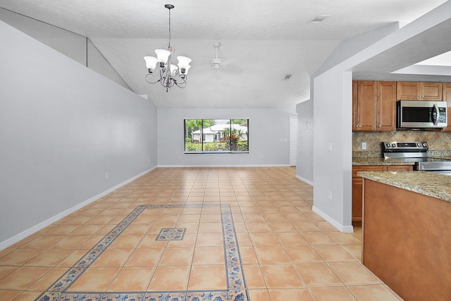 515 SE Nome Dr, Port Saint Lucie, FL 34984 - kitchen with stainless steel appliances, light tile patterned floors, lofted ceiling, open floor plan, and brown cabinets