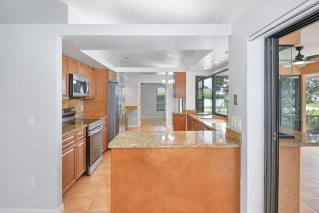 515 SE Nome Dr, Port Saint Lucie, FL 34984 - kitchen featuring stainless steel appliances, a sink, light tile patterned flooring, and backsplash