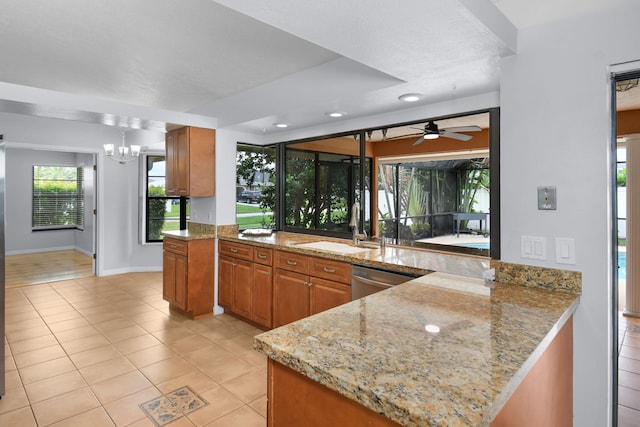 515 SE Nome Dr, Port Saint Lucie, FL 34984 - kitchen with dishwasher, brown cabinetry, light tile patterned floors, a peninsula, and recessed lighting
