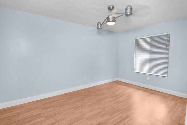 515 SE Nome Dr, Port Saint Lucie, FL 34984 - unfurnished room featuring light wood finished floors, a textured ceiling, and baseboards