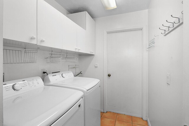 515 SE Nome Dr, Port Saint Lucie, FL 34984 - laundry area featuring cabinet space, independent washer and dryer, light tile patterned floors, and a textured ceiling