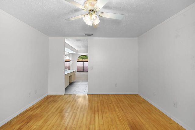 515 SE Nome Dr, Port Saint Lucie, FL 34984 - empty room with a textured ceiling, light wood-style flooring, a ceiling fan, and baseboards