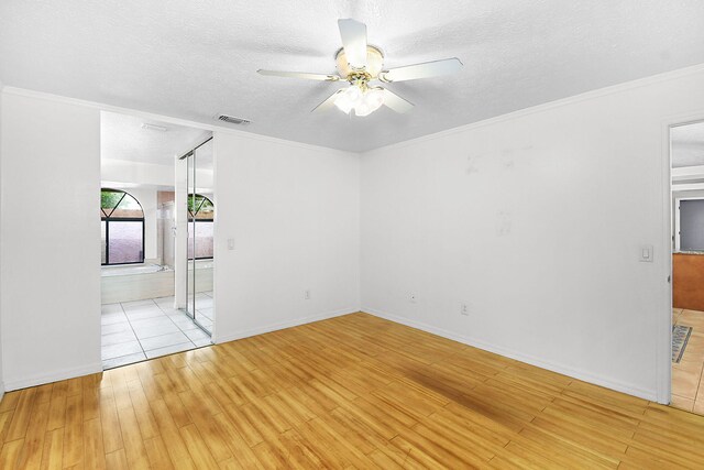 515 SE Nome Dr, Port Saint Lucie, FL 34984 - spare room with ceiling fan, light wood-style flooring, a textured ceiling, ornamental molding, and baseboards