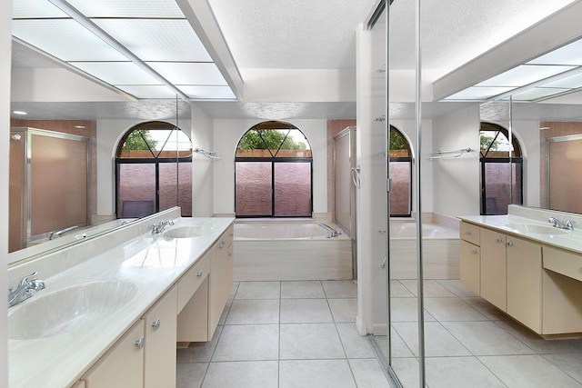 515 SE Nome Dr, Port Saint Lucie, FL 34984 - bathroom with a bath, a stall shower, double vanity, tile patterned flooring, and a textured ceiling