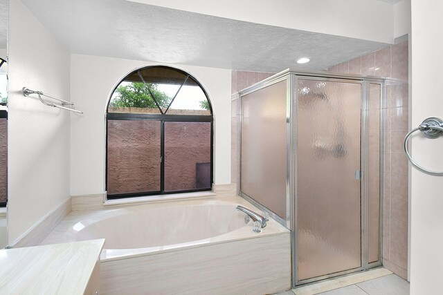 515 SE Nome Dr, Port Saint Lucie, FL 34984 - full bathroom with a shower stall, a garden tub, tile patterned flooring, and a textured ceiling