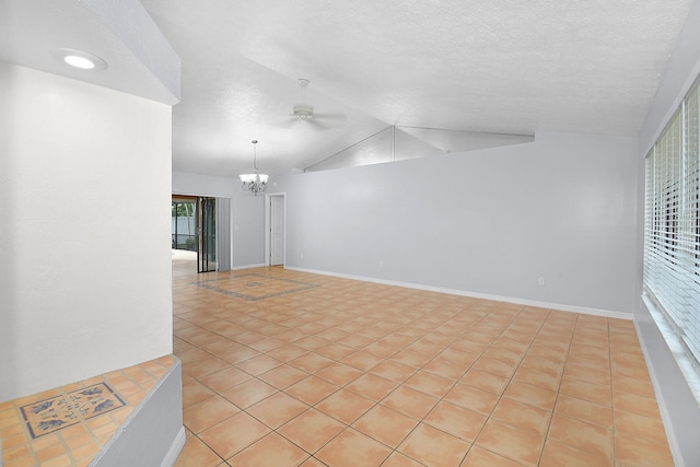 515 SE Nome Dr, Port Saint Lucie, FL 34984 - spare room featuring lofted ceiling, a chandelier, a ceiling fan, a textured ceiling, and light tile patterned flooring